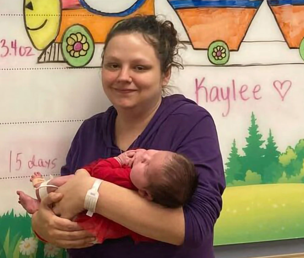 mother holding sleeping newborn child in her arms