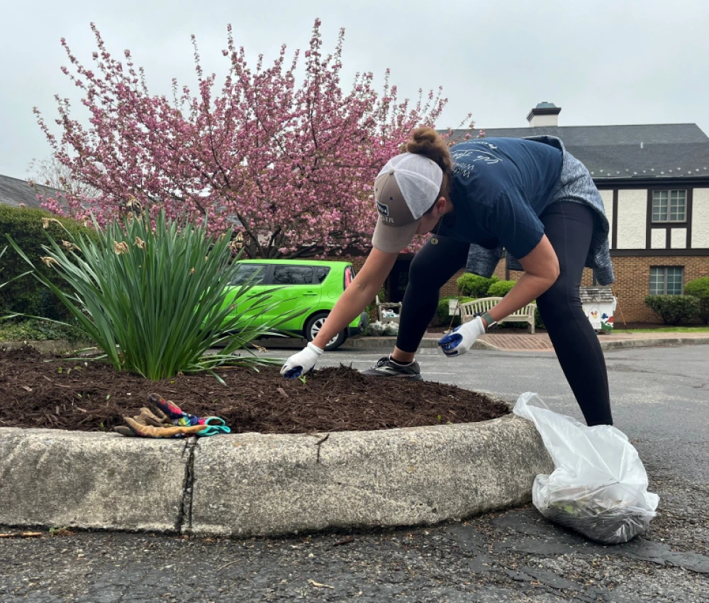 a volunteer working to clean a flowerbed