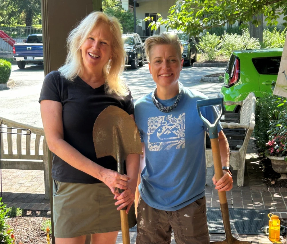 two volunteers with shovels working outside on behalf of the Ronald McDonald house