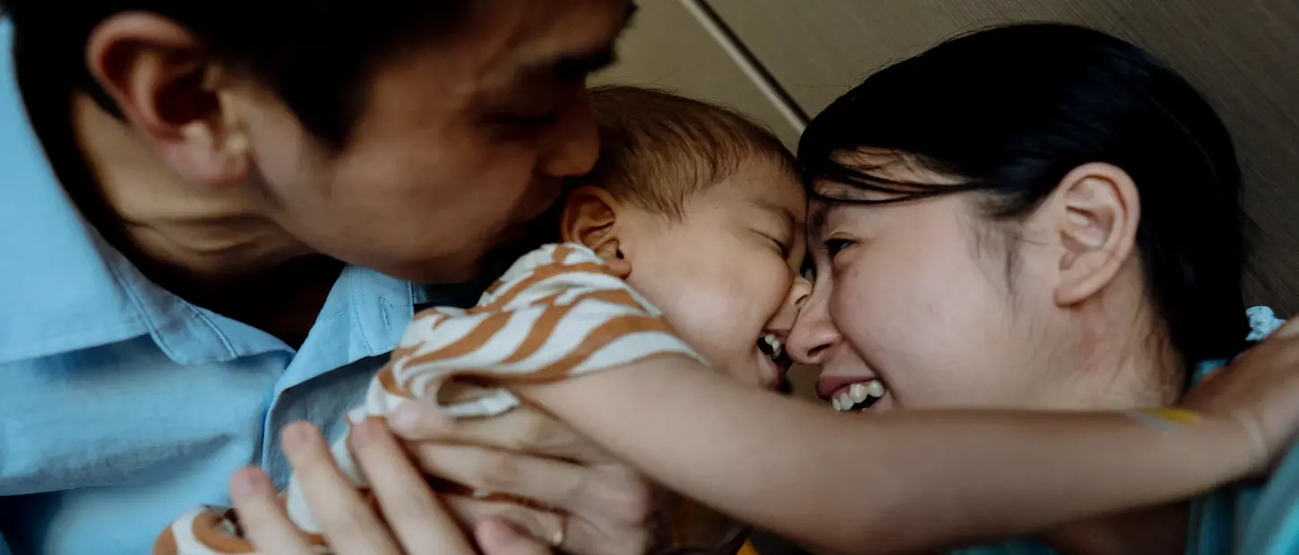 mother and father loving on child