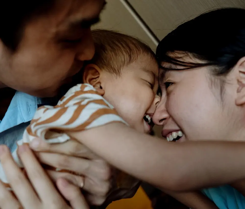 mother and father loving on child
